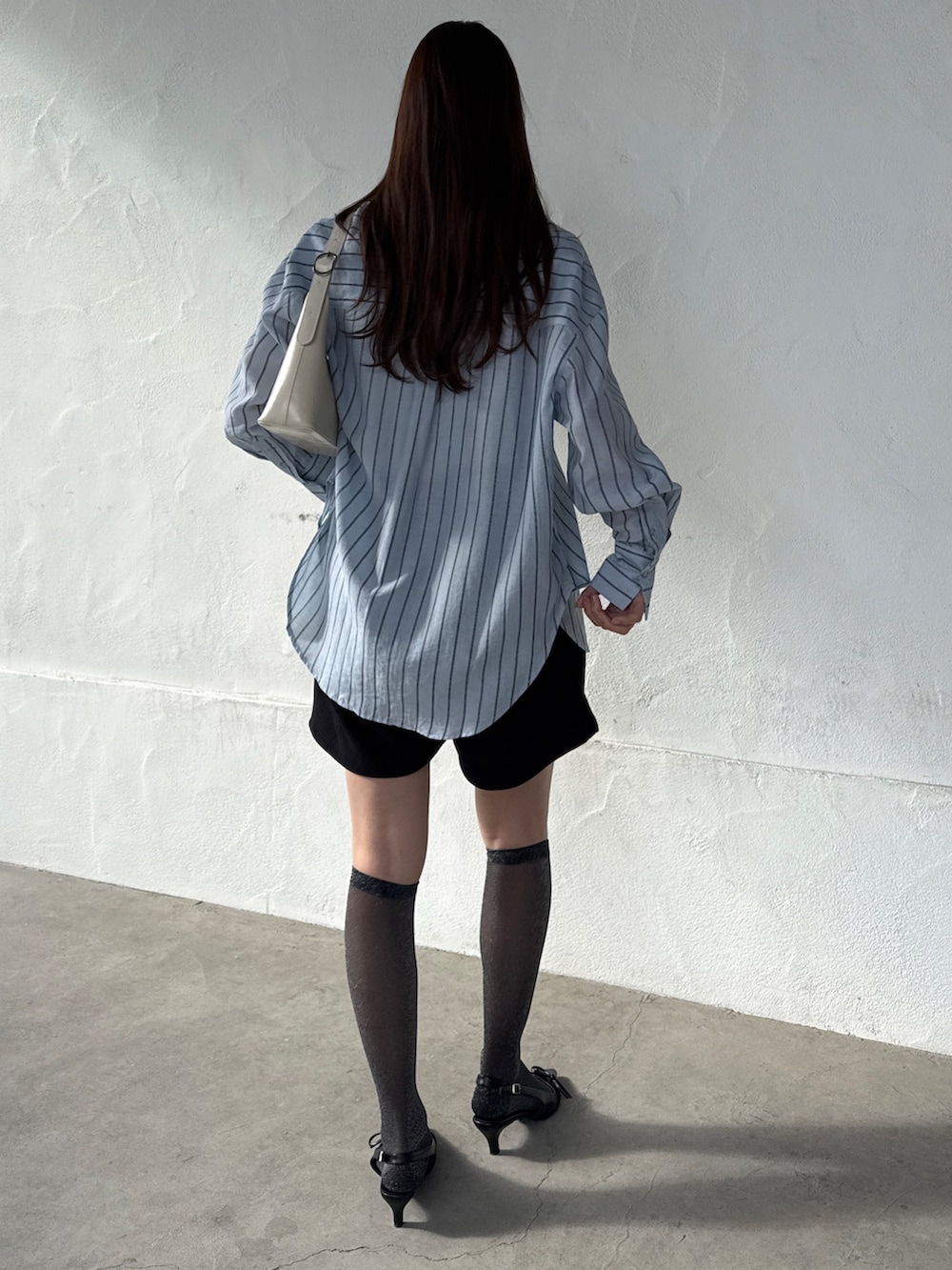 ブルー系のシャツ/ブラウスを着用したレディースの春コーディネートの2枚目の写真