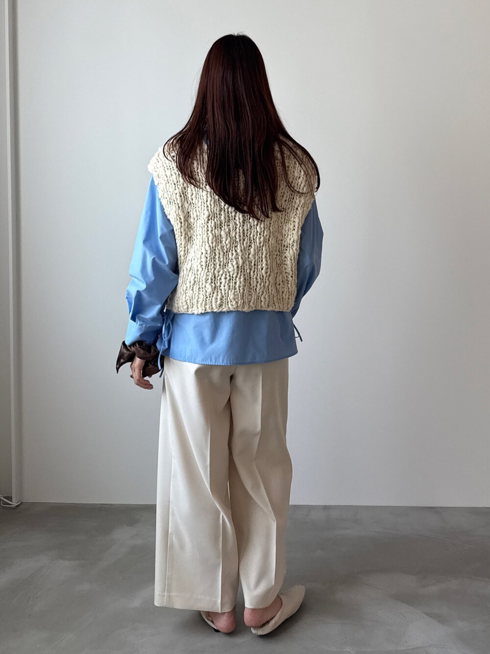 ホワイト系のベスト、ブルー系のシャツ/ブラウス、ホワイト系のスラックスを着用したレディースの秋コーディネートの2枚目の写真