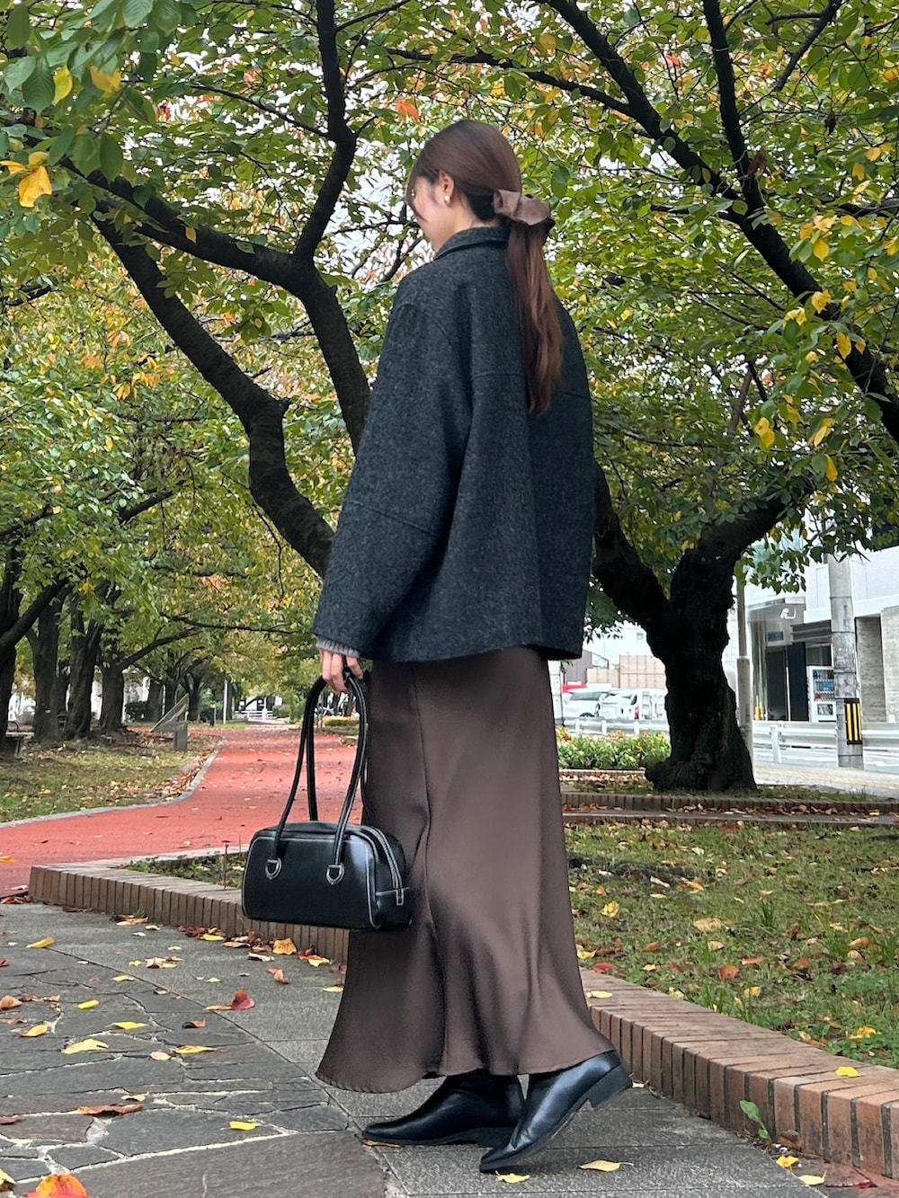 グレー系のその他アウター、グレー系のニット/セーター、ブラウン系のスカートを着用したレディースの秋コーディネートの3枚目の写真