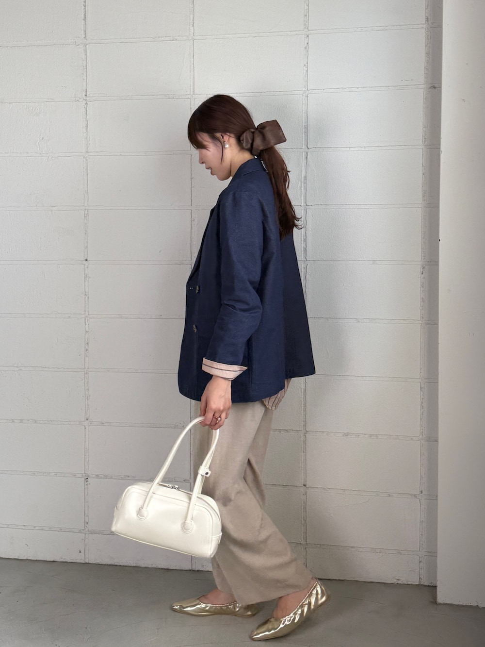 ブルー系のテーラードジャケット、ピンク系のシャツ/ブラウス、ベージュ系のその他パンツを着用したレディースの秋コーディネートの3枚目の写真