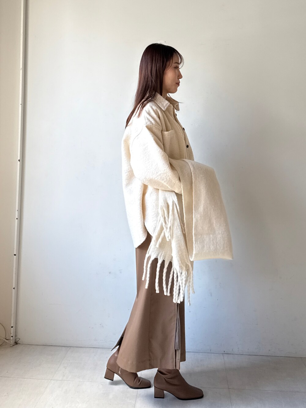 ホワイト系のその他アウター、ブラウン系のスカートを着用したレディースの冬コーディネートの2枚目の写真