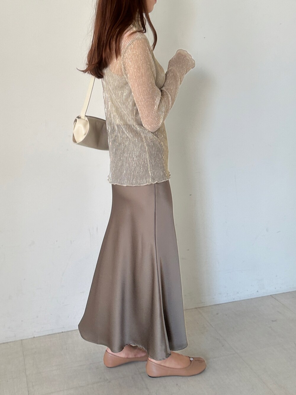 ゴールド系のTシャツ/カットソー、ブラウン系のスカートを着用したレディースの秋コーディネートの3枚目の写真