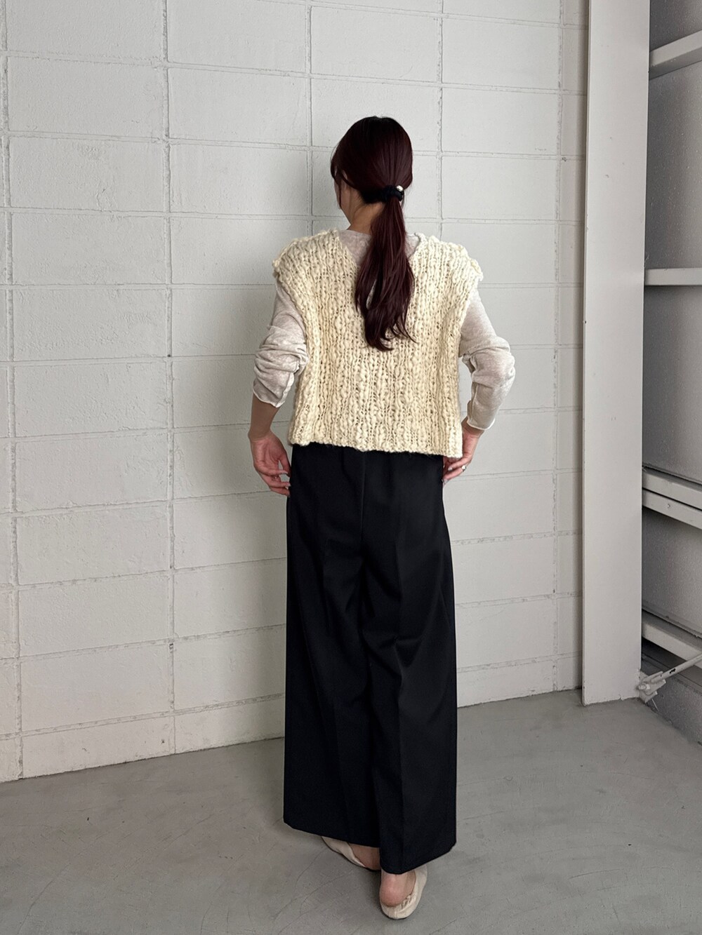 ホワイト系のベスト、ブラック系のスカート、ベージュ系のTシャツ/カットソーを着用したレディースの秋コーディネートの2枚目の写真