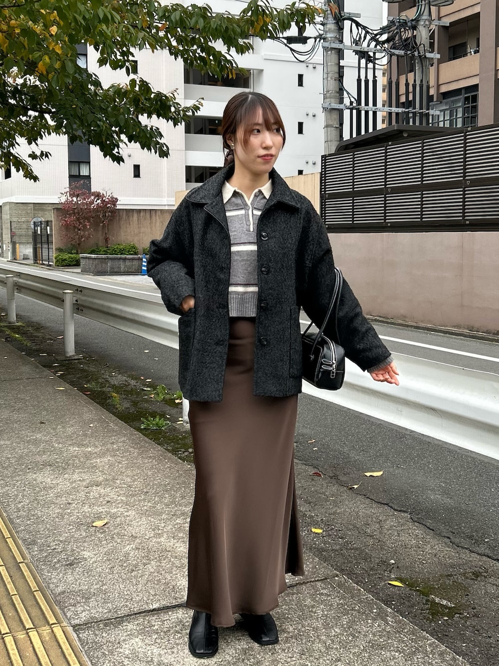 グレー系のその他アウター、グレー系のニット/セーター、ブラウン系のスカートを着用したレディースの秋コーディネートの2枚目の写真