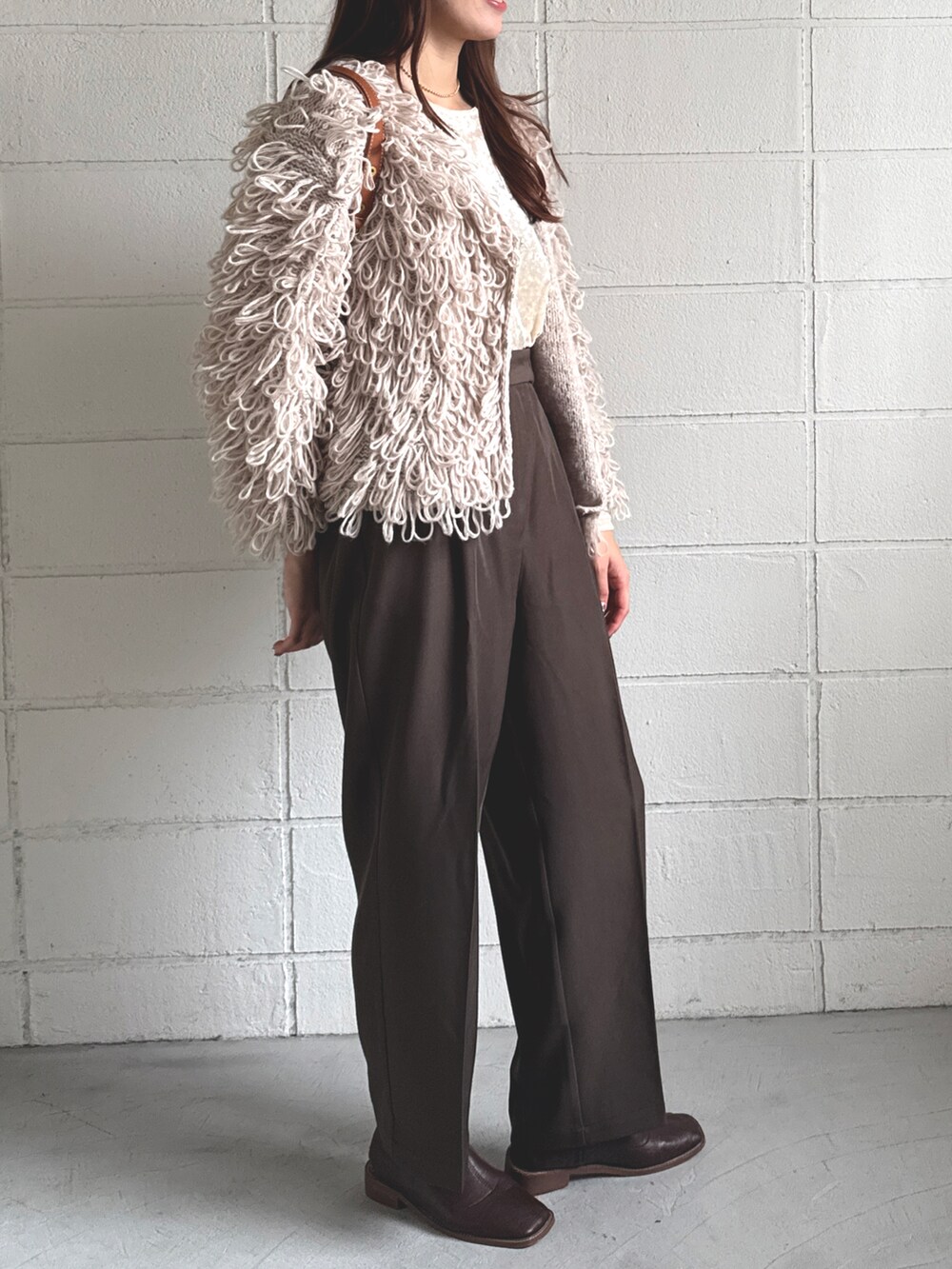 ホワイト系のTシャツ/カットソー、ベージュ系のカーディガン/ボレロ、ブラウン系のスラックスを着用したレディースの秋コーディネートの3枚目の写真