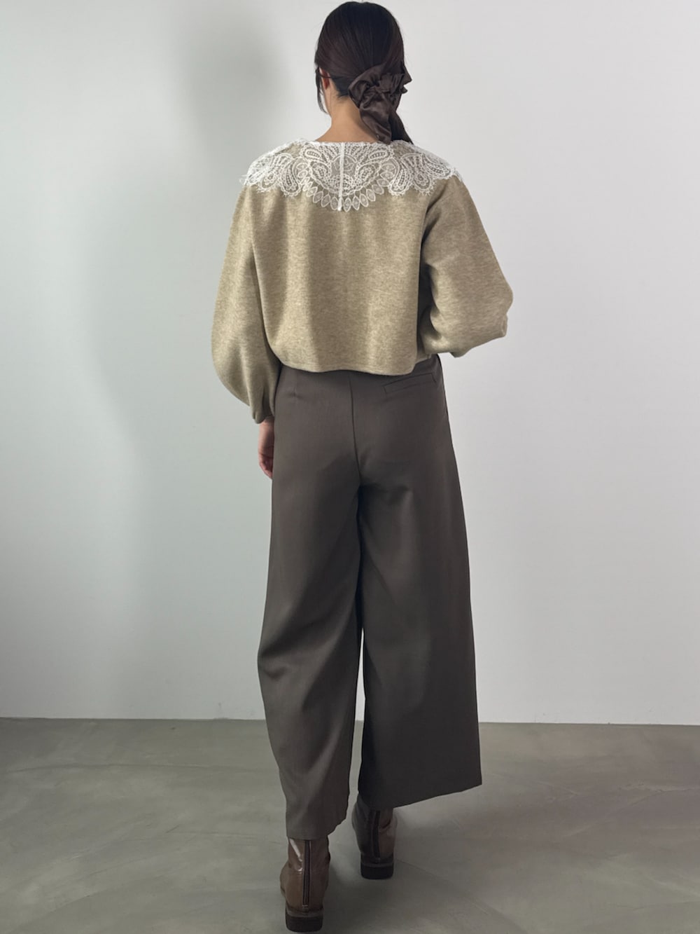 ブラウン系のスラックス、ベージュ系のカーディガン/ボレロを着用したレディースの秋コーディネートの2枚目の写真