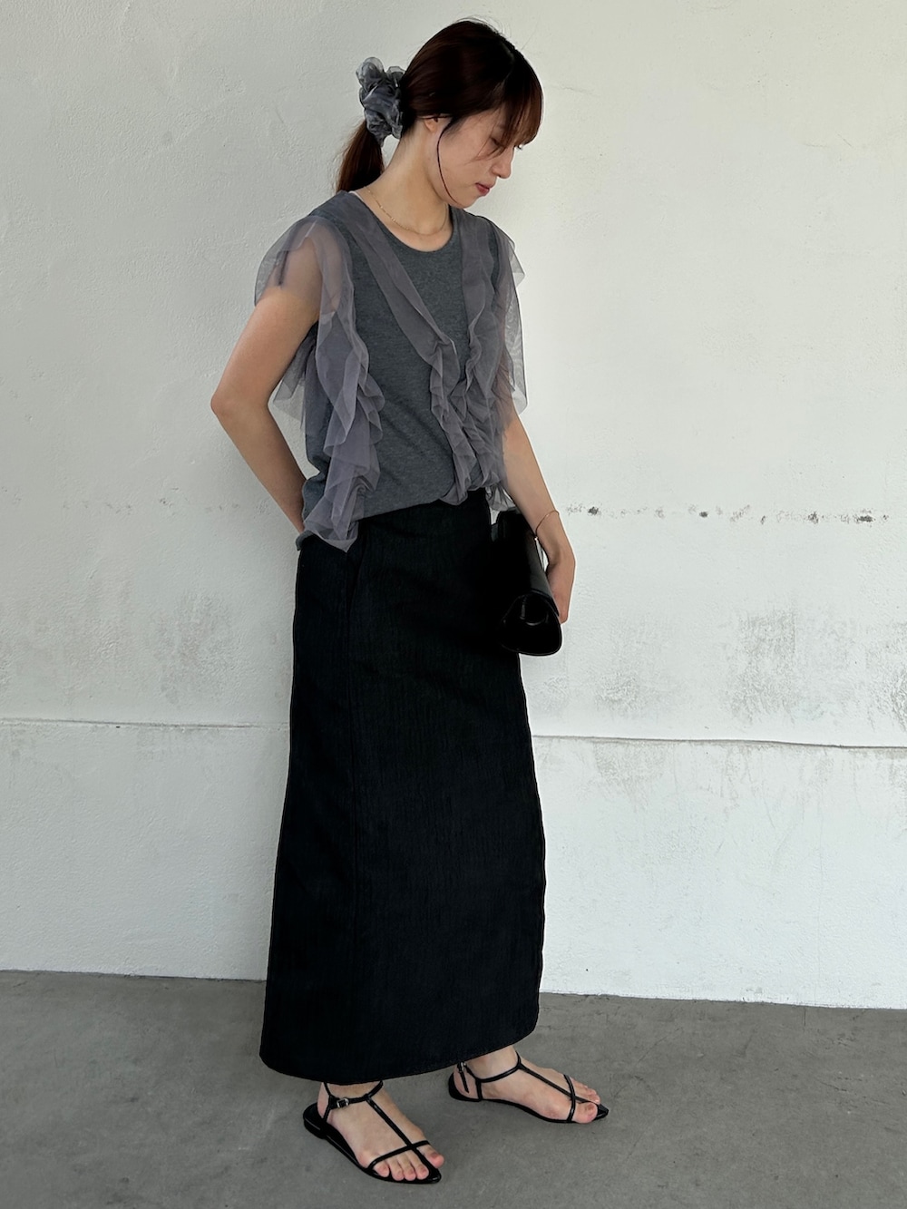 ブラック系のデニムスカート、グレー系のTシャツ/カットソーを着用したレディースの夏コーディネートの2枚目の写真