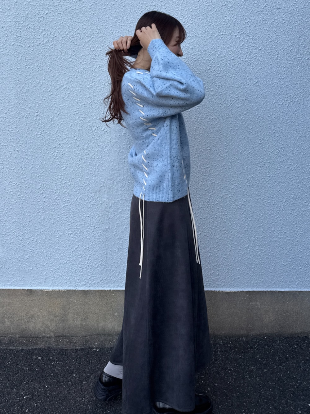 ブルー系のニット/セーター、グレー系のスカートを着用したレディースの秋コーディネートの2枚目の写真