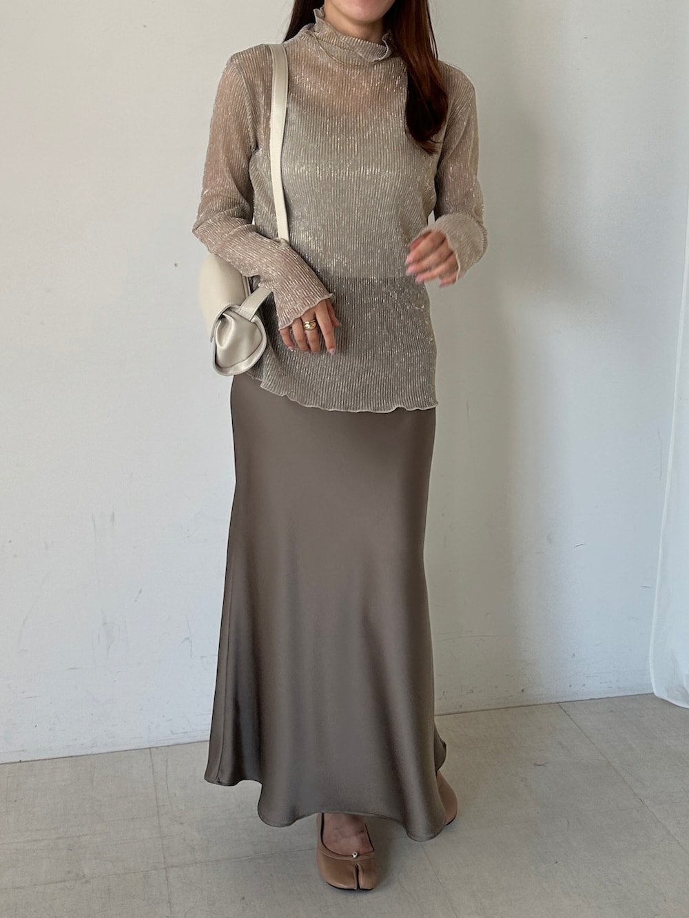 ゴールド系のTシャツ/カットソー、ブラウン系のスカートを着用したレディースの秋コーディネートの2枚目の写真