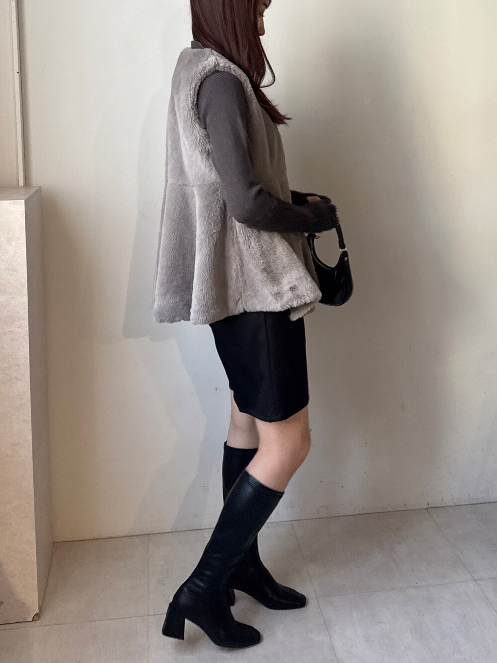 グレー系のニット/セーター、グレー系のベスト、ブラック系のその他パンツを着用したレディースの秋コーディネートの3枚目の写真