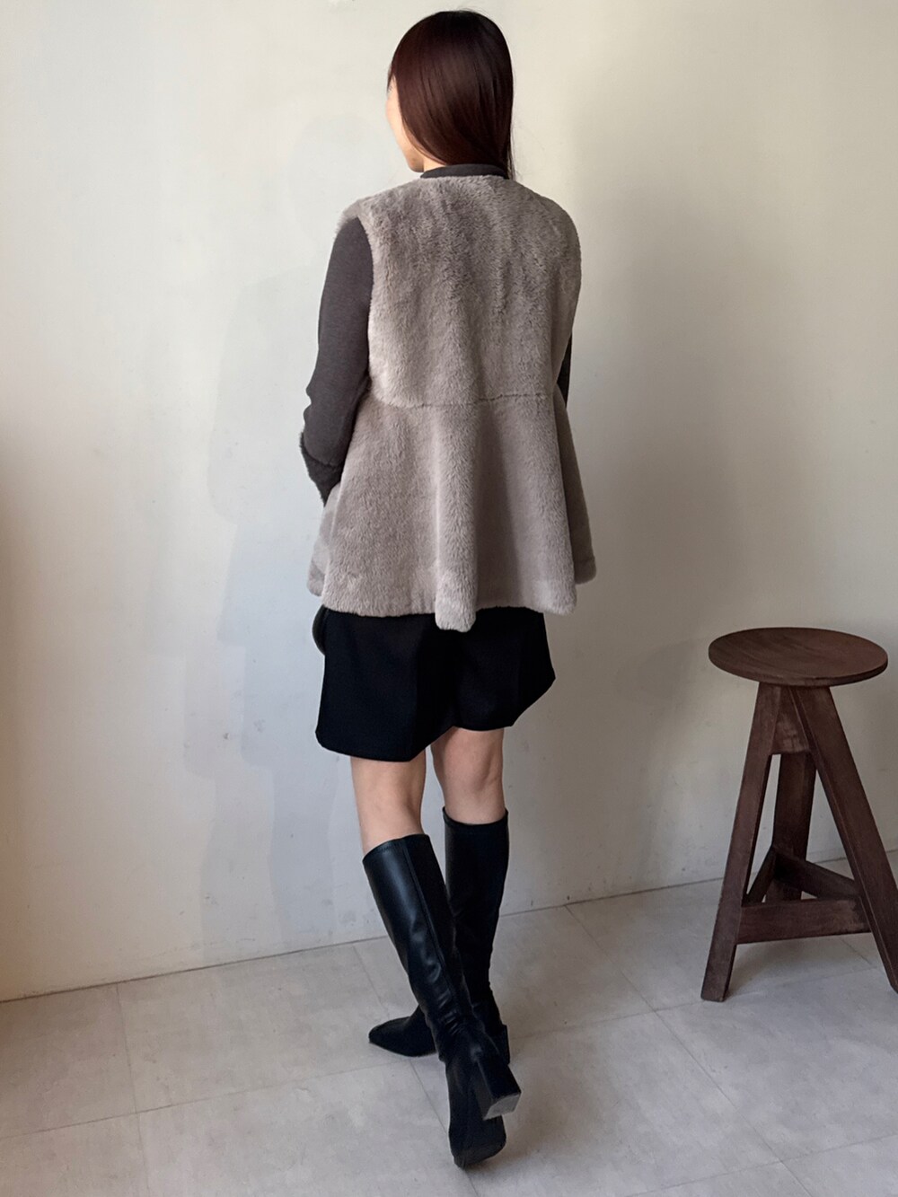 グレー系のニット/セーター、グレー系のベスト、ブラック系のその他パンツを着用したレディースの秋コーディネートの4枚目の写真