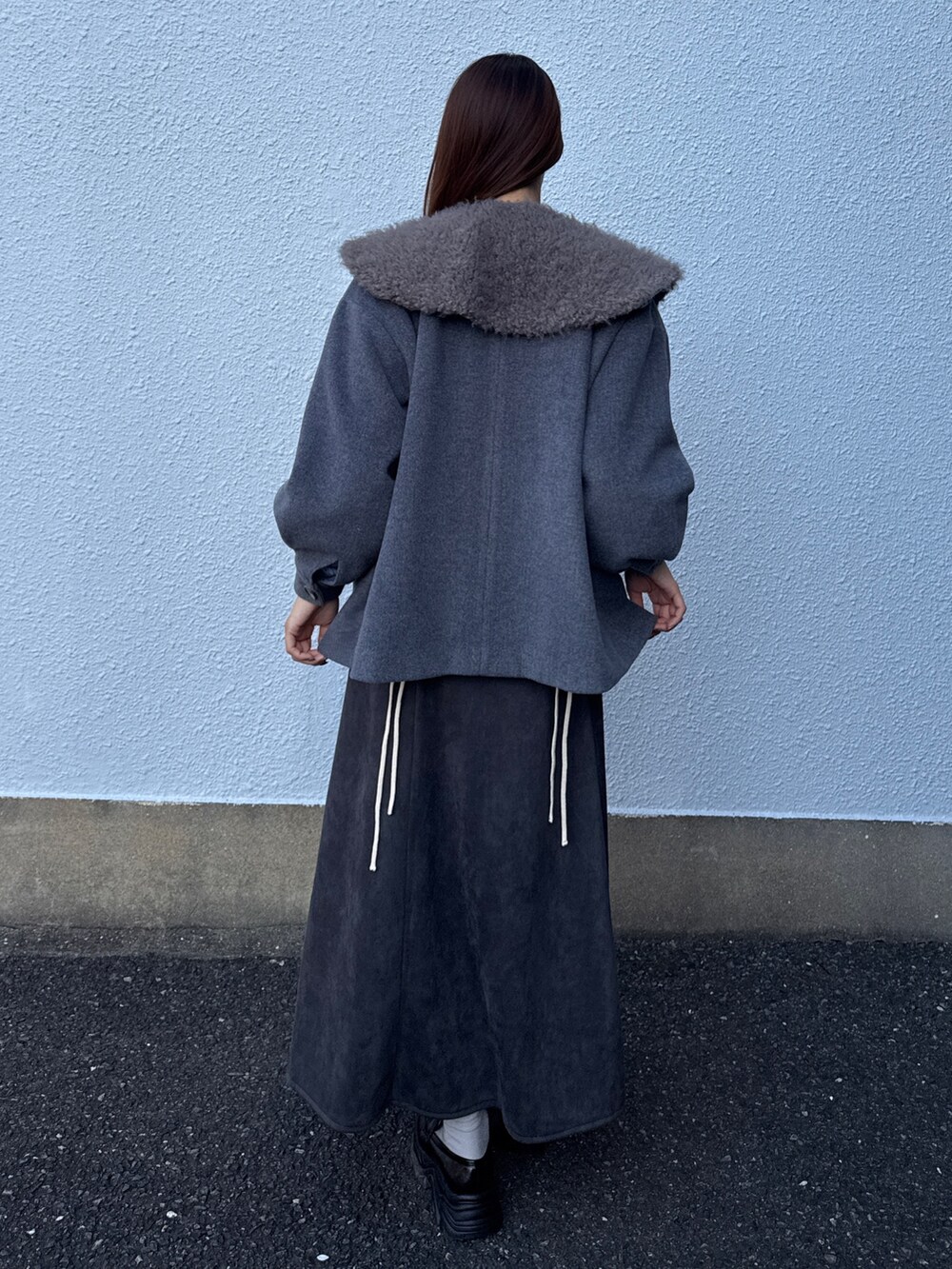 グレー系のダウンジャケット/コート、ブルー系のニット/セーター、グレー系のスカートを着用したレディースの秋コーディネートの3枚目の写真