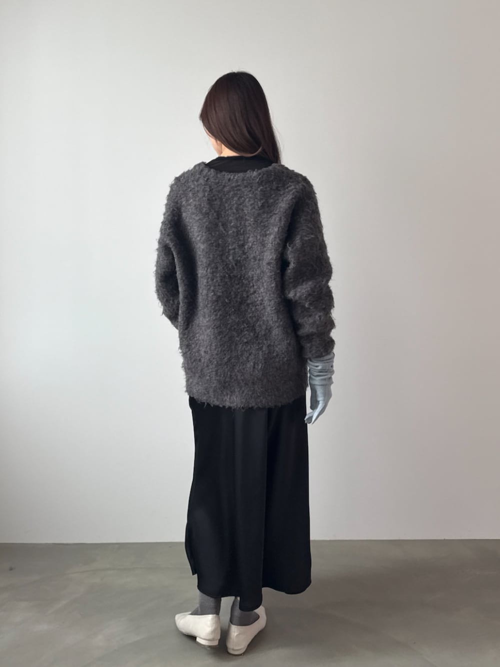 ブラウン系のカーディガン/ボレロ、ブラック系のスカート、ブルー系の手袋を着用したレディースの秋コーディネートの2枚目の写真