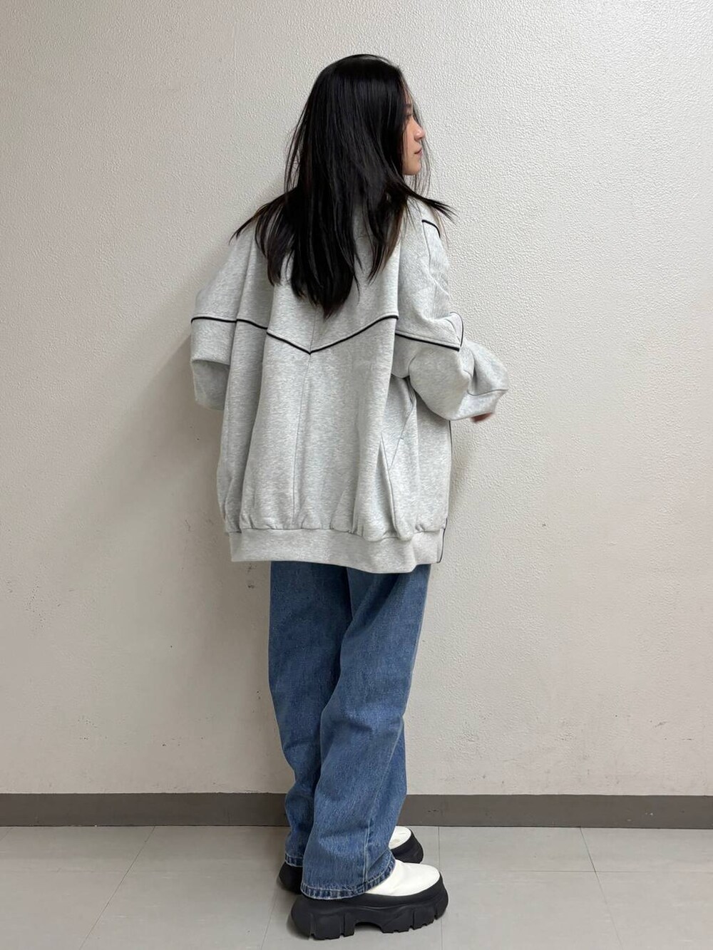 ブルー系のタンクトップ、ブルー系のデニムパンツ、ホワイト系のブーツを着用したレディースの冬コーディネートの4枚目の写真