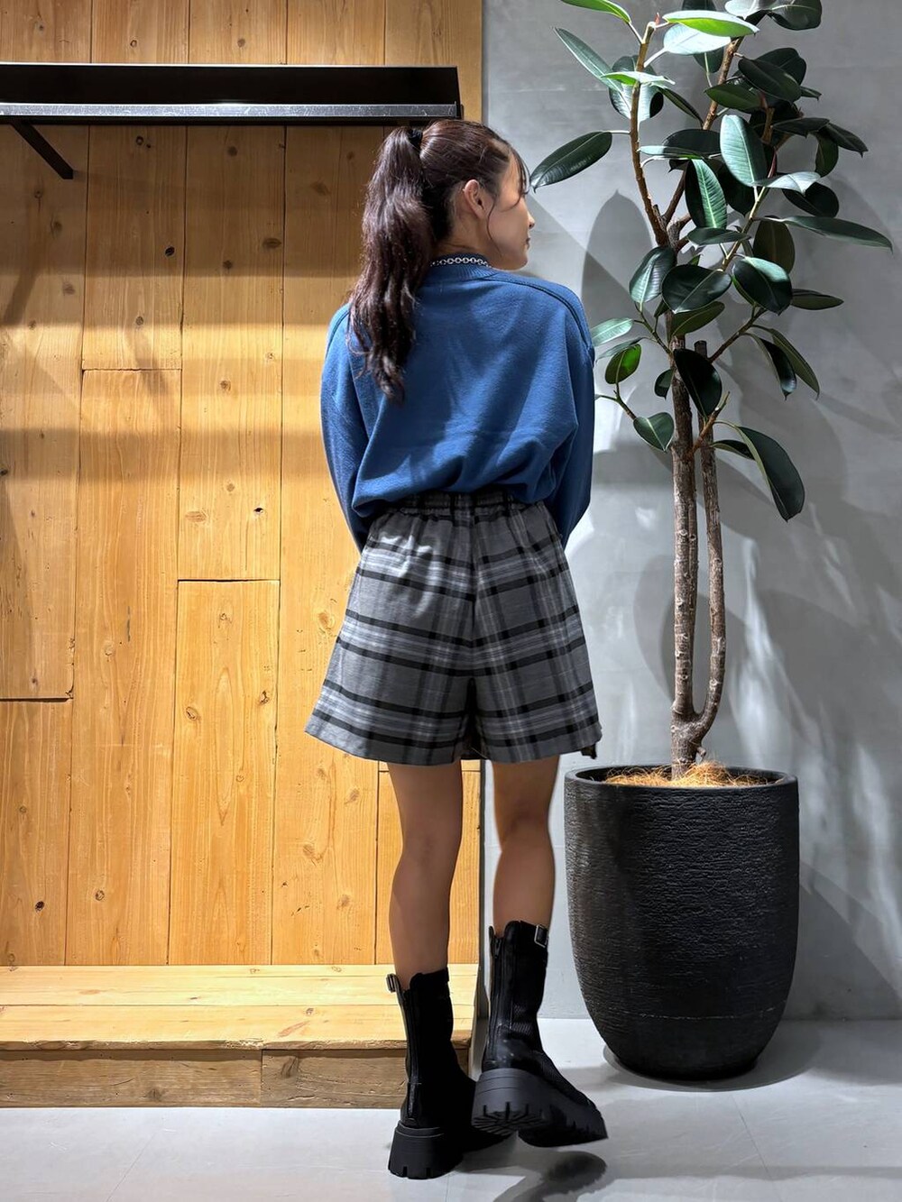 ブラック系のブーツ、グレー系のその他パンツ、ブルー系のニット/セーターを着用したレディースの秋コーディネートの3枚目の写真
