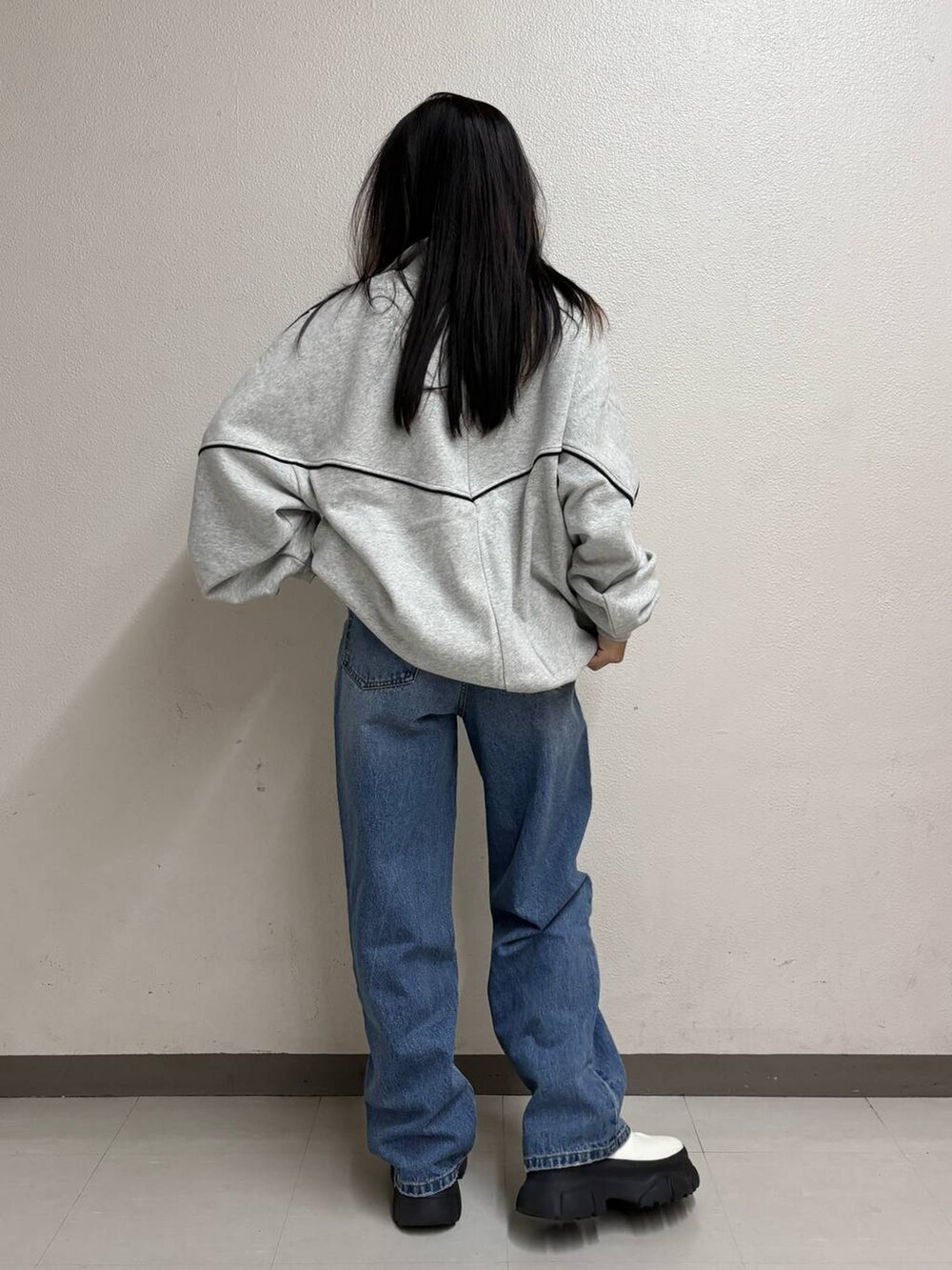 ブルー系のタンクトップ、ブルー系のデニムパンツ、ホワイト系のブーツを着用したレディースの冬コーディネートの2枚目の写真