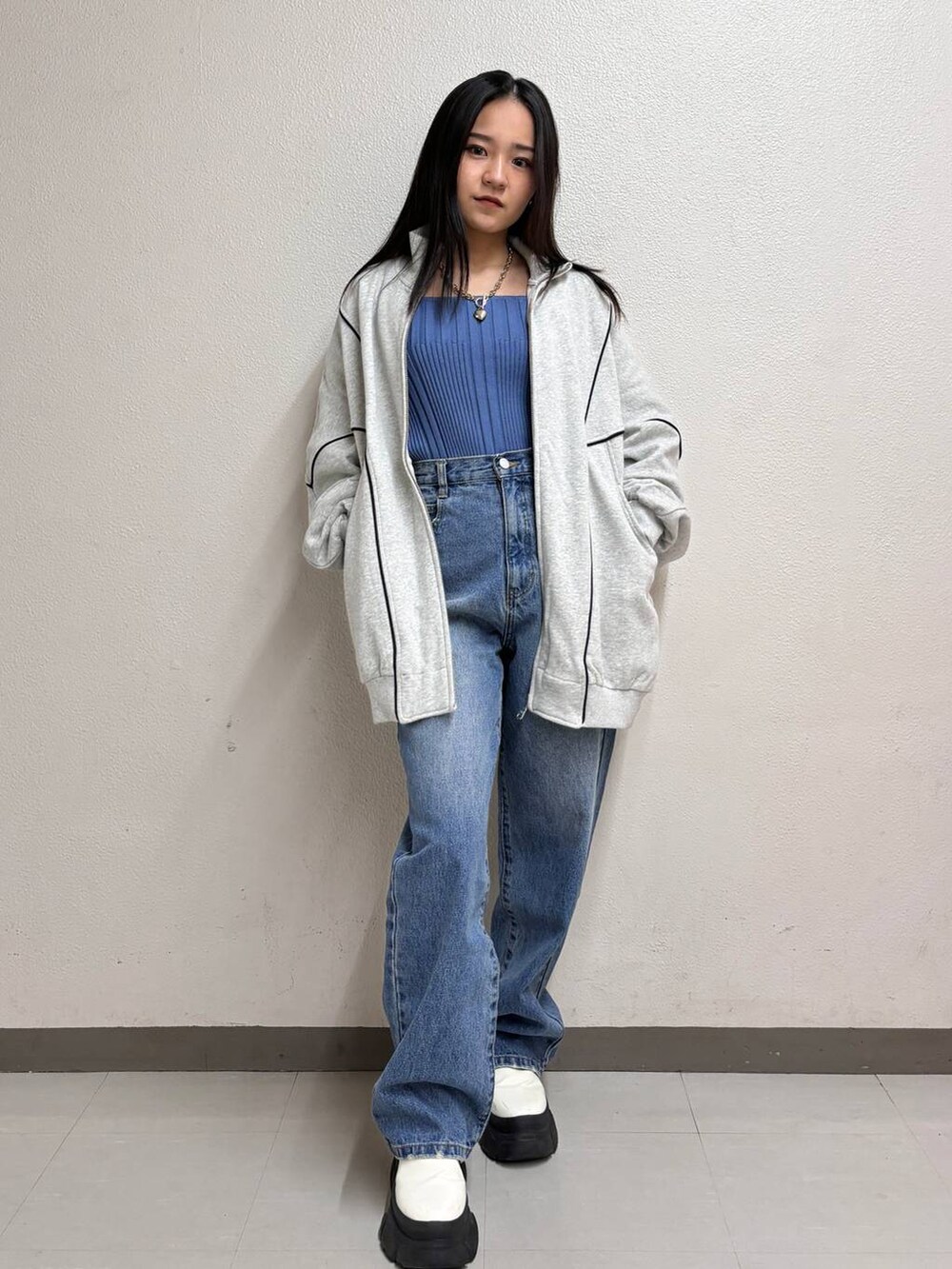 ブルー系のタンクトップ、ブルー系のデニムパンツ、ホワイト系のブーツを着用したレディースの冬コーディネートの3枚目の写真