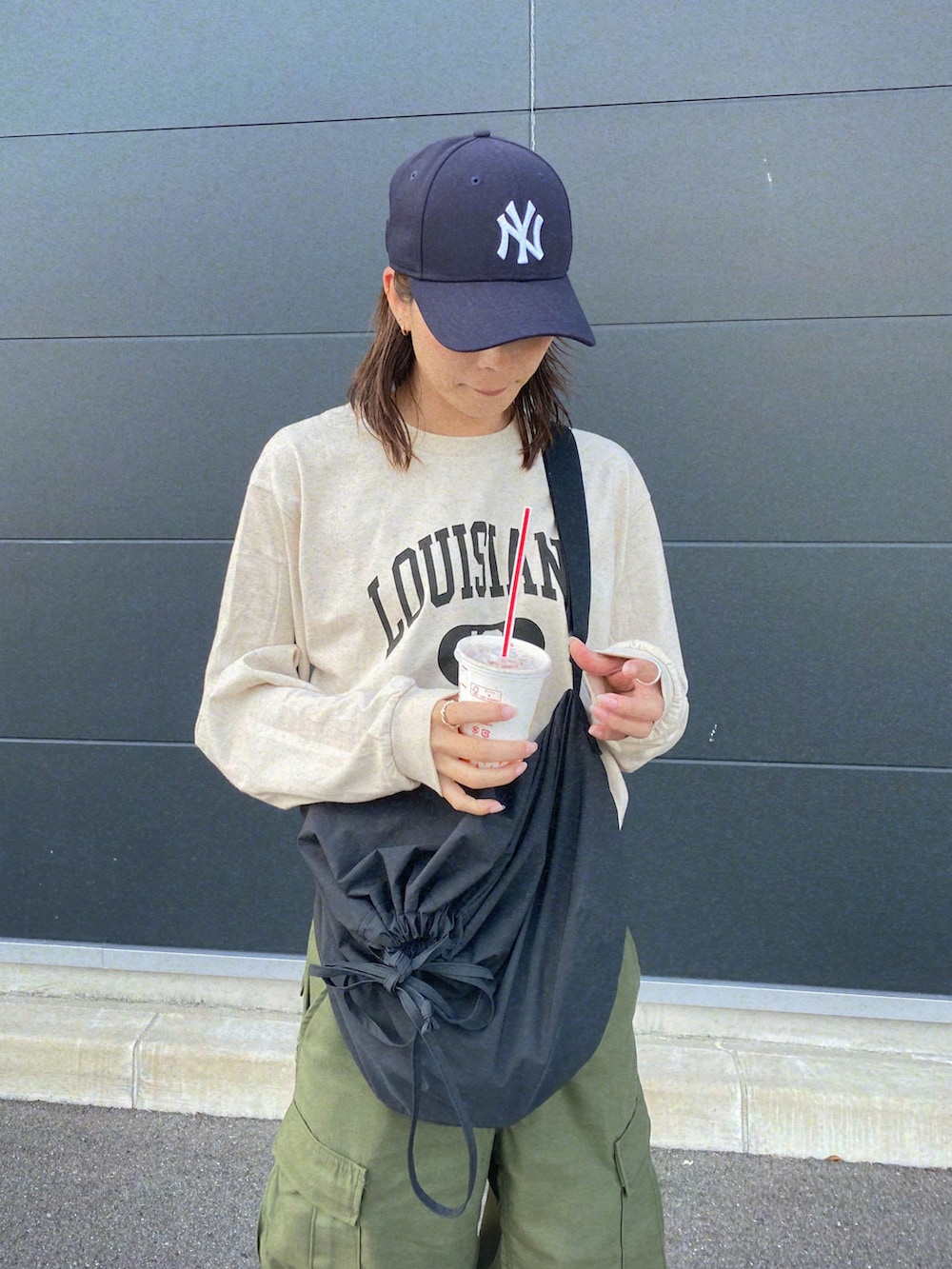 グリーン系のカーゴパンツ、ブラック系のスニーカーを着用したレディースの秋コーディネートの2枚目の写真