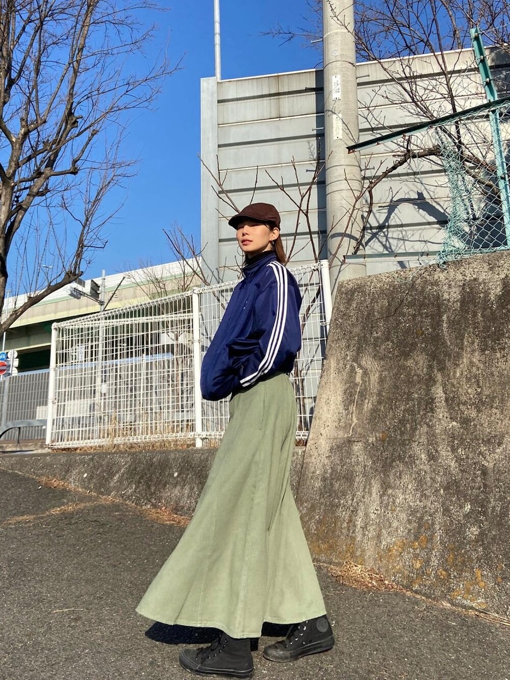 グリーン系のスカート、ブルー系のジャージを着用したレディースの冬コーディネートの3枚目の写真