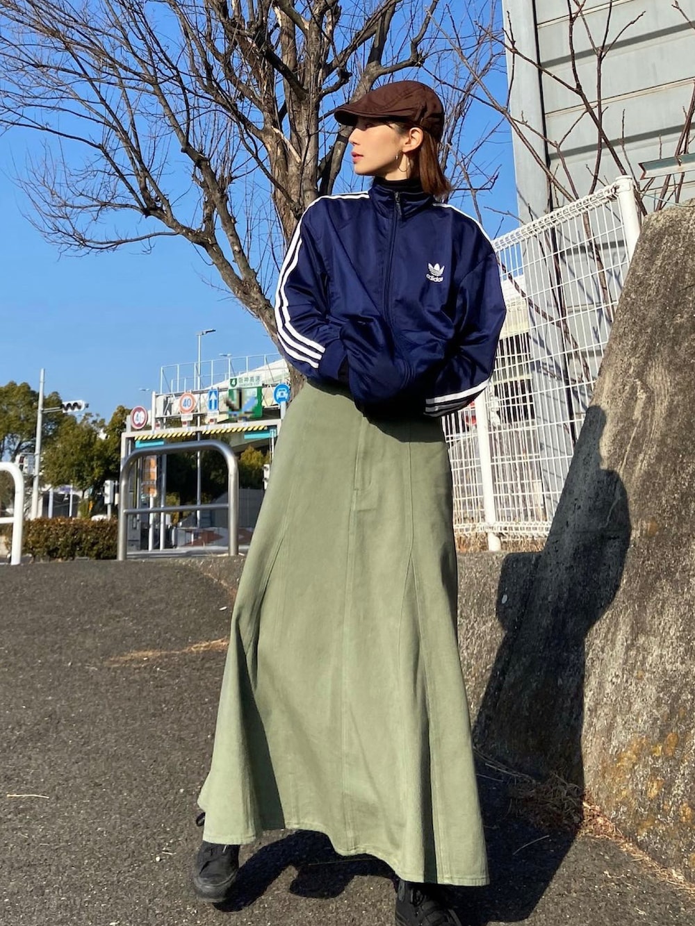 グリーン系のスカート、ブルー系のジャージを着用したレディースの冬コーディネートの2枚目の写真