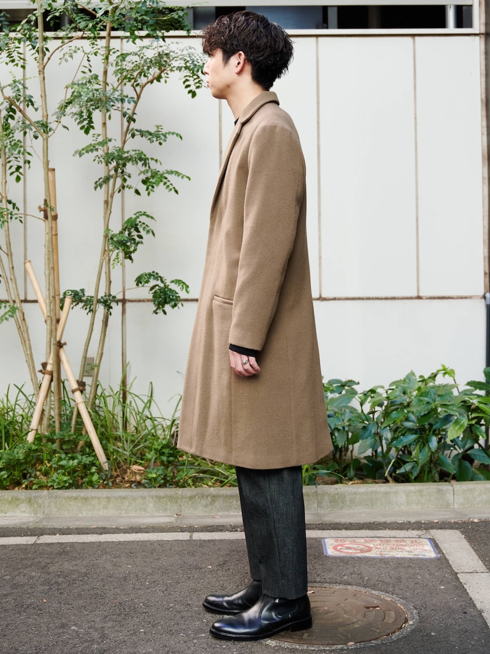 ベージュ系のチェスターコートを着用したメンズの冬コーディネートの2枚目の写真
