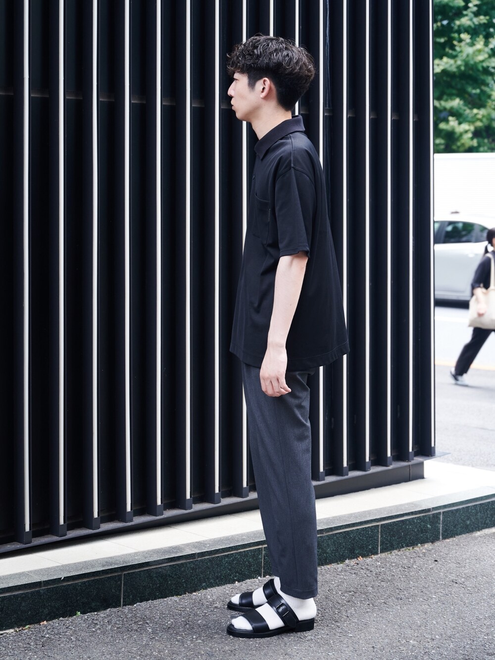 ブラック系のポロシャツを着用したメンズの夏コーディネートの2枚目の写真