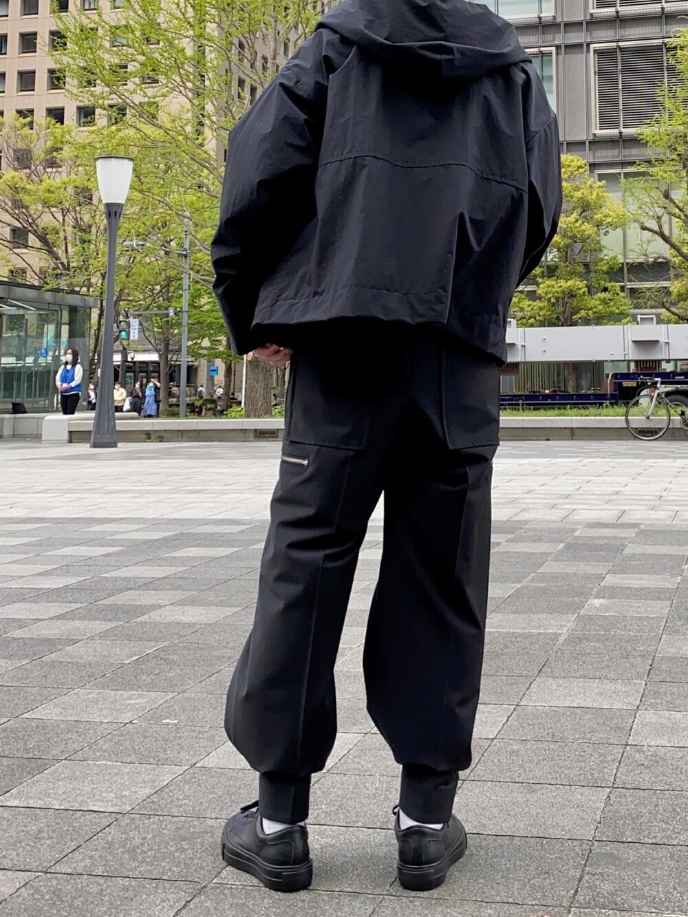 ブラック系のニット/セーター、ブラック系のマウンテンパーカー、ブラック系のカーゴパンツを着用したメンズの春コーディネートの2枚目の写真