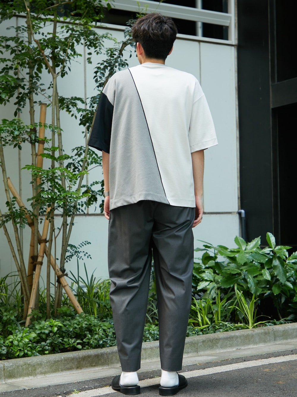 グレー系のTシャツ/カットソー、グレー系のスラックスを着用したメンズの春コーディネートの3枚目の写真