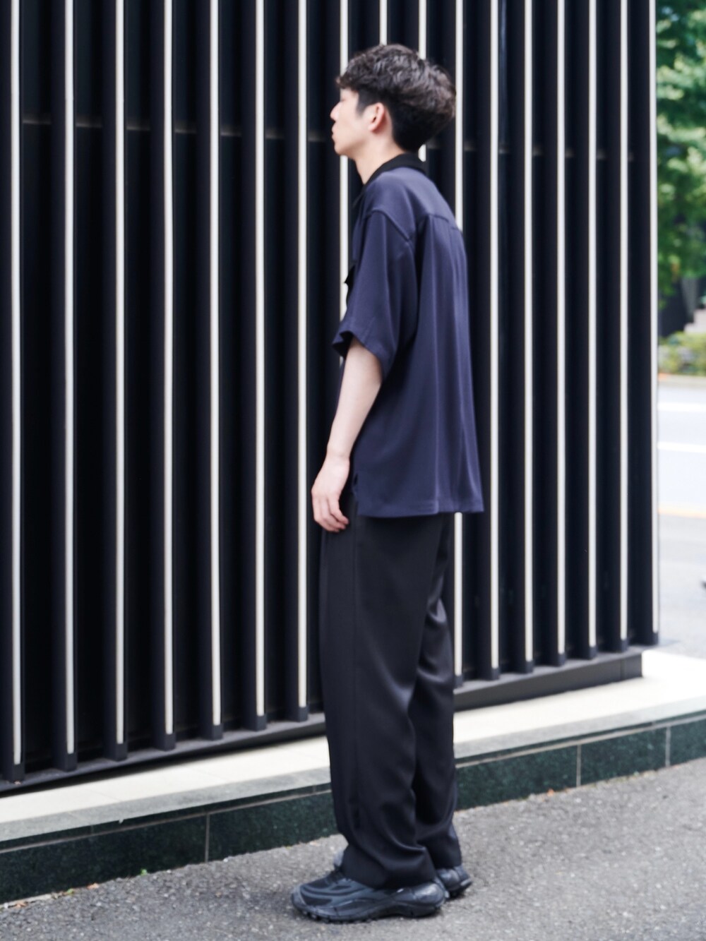 ブラック系のスラックスを着用したメンズの夏コーディネートの2枚目の写真