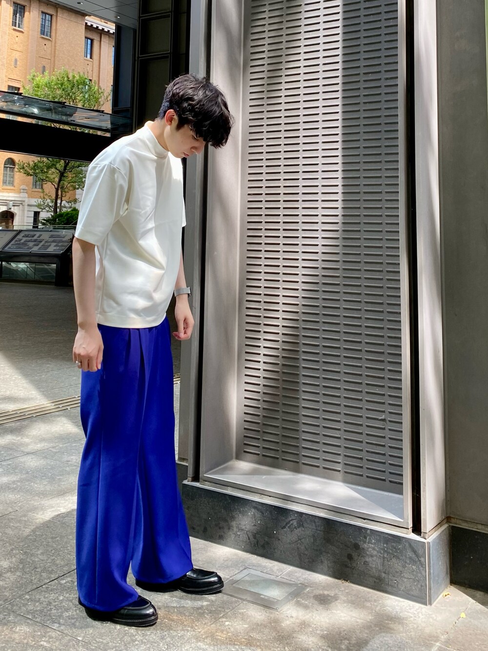 ホワイト系のTシャツ/カットソー、ブルー系のスラックスを着用したメンズの夏コーディネートの2枚目の写真