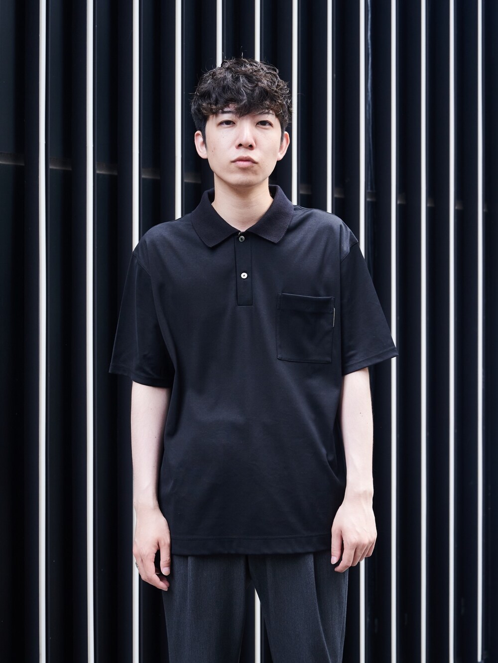 ブラック系のポロシャツを着用したメンズの夏コーディネートの4枚目の写真