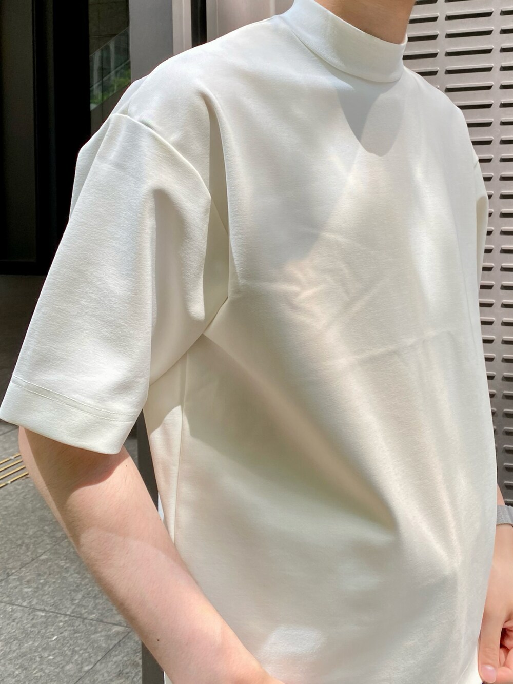 ホワイト系のTシャツ/カットソー、ブルー系のスラックスを着用したメンズの夏コーディネートの4枚目の写真