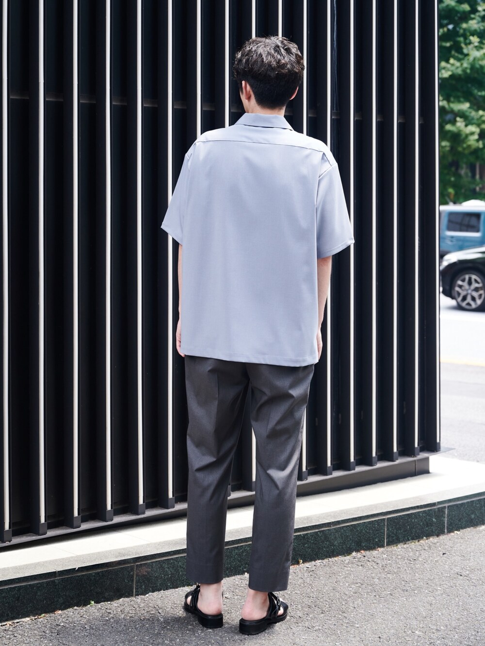 ブラック系のスラックスを着用したメンズの夏コーディネートの3枚目の写真