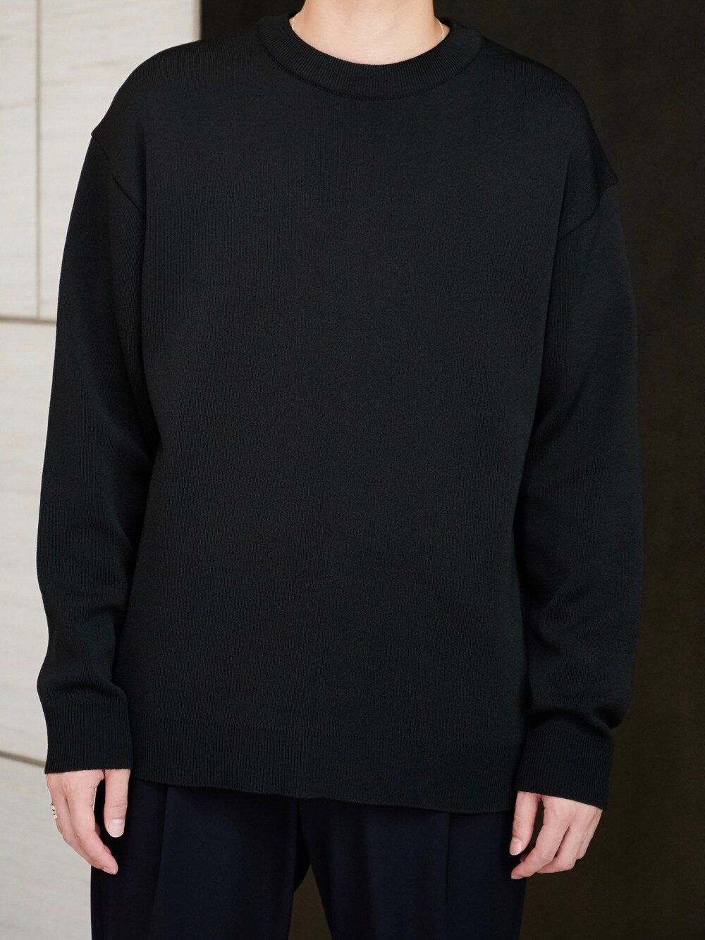 ブラック系のニット/セーター、ブルー系のスラックスを着用したメンズの秋コーディネートの4枚目の写真