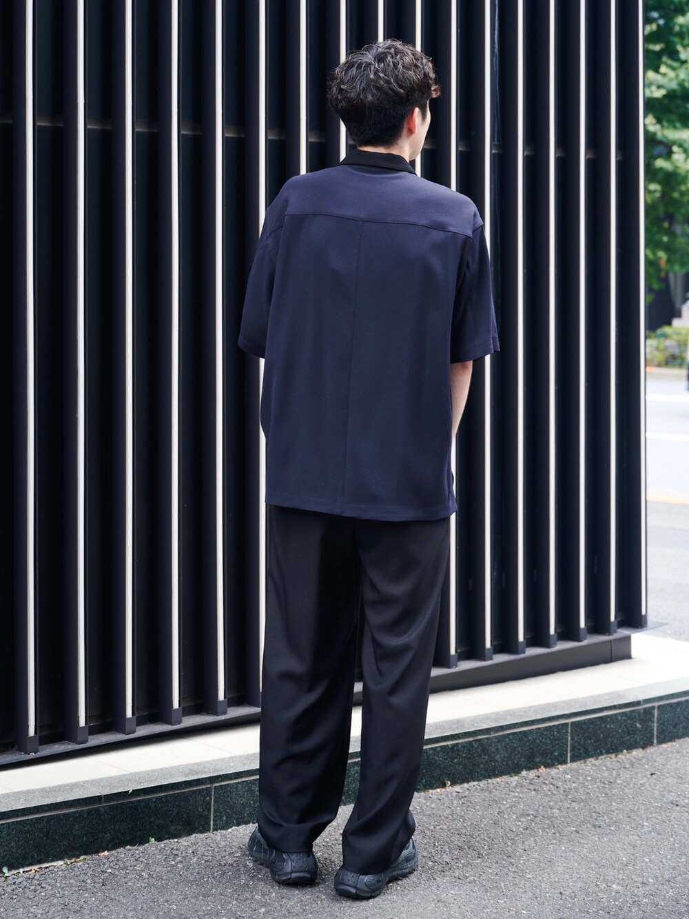 ブラック系のスラックスを着用したメンズの夏コーディネートの3枚目の写真