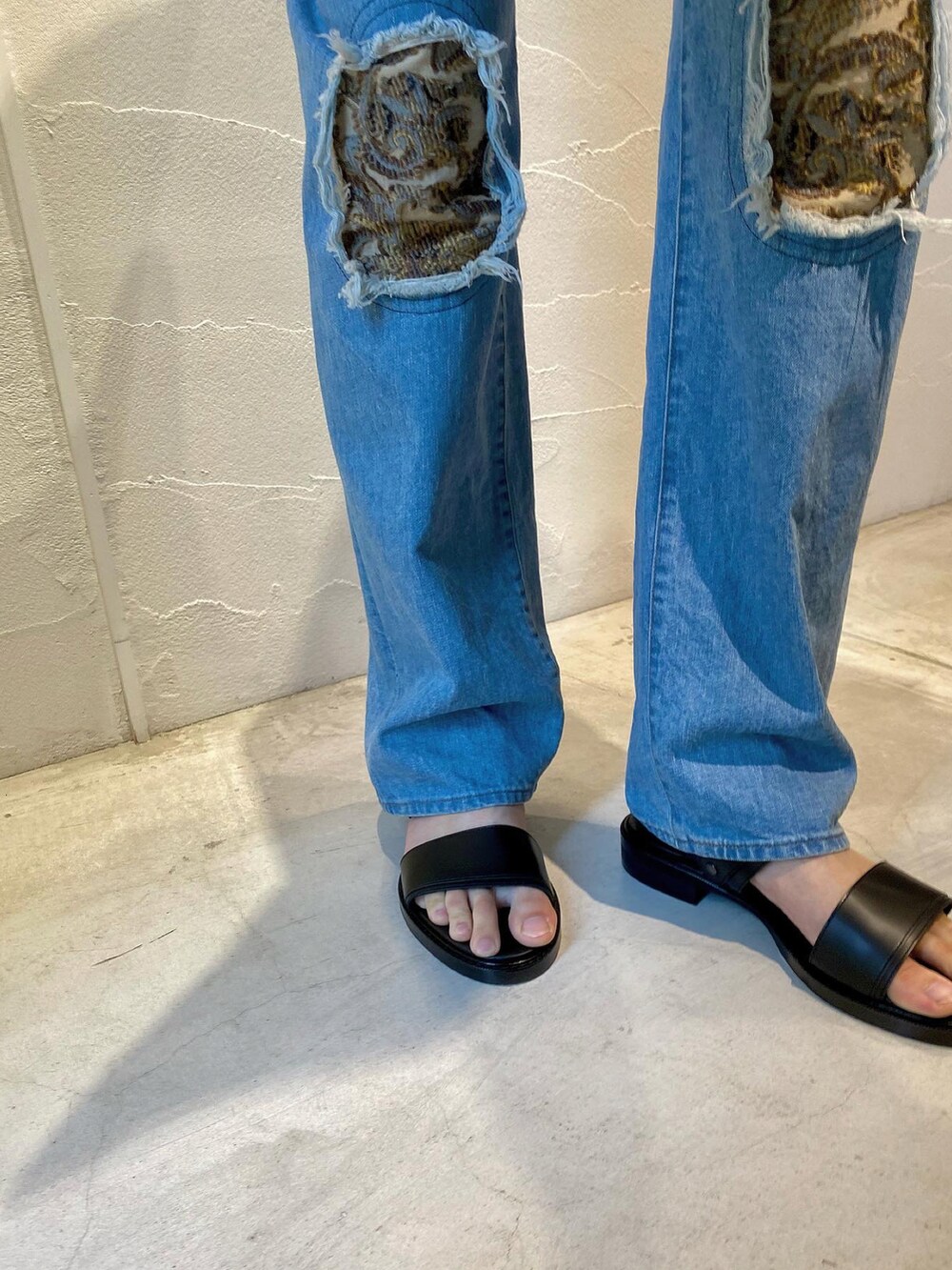 ブルー系のデニムパンツ、グレー系のシャツ/ブラウス、ブラック系のサンダルを着用したメンズの春コーディネートの3枚目の写真