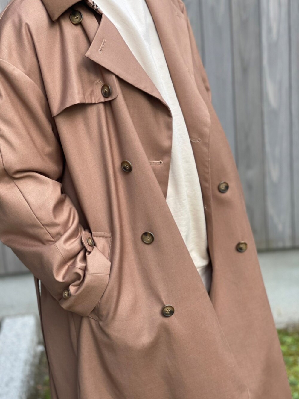 ベージュ系のトレンチコート、ブラック系のスニーカーを着用したメンズの春コーディネートの2枚目の写真