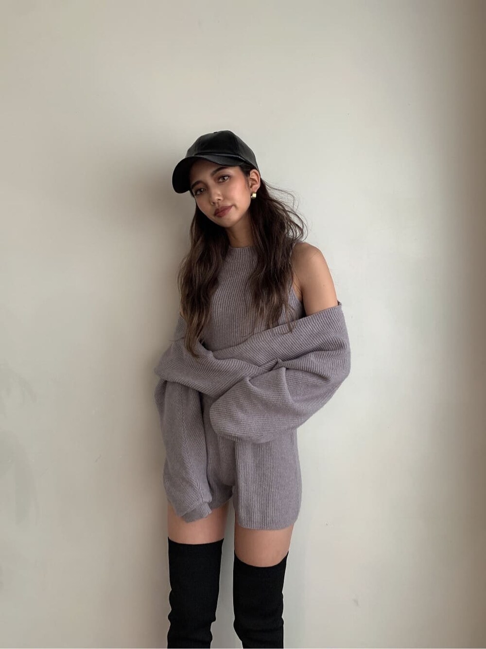 グレー系のつなぎ/オールインワン、ブラック系のブーツ、ブラック系のキャップを着用したレディースの秋コーディネートの2枚目の写真