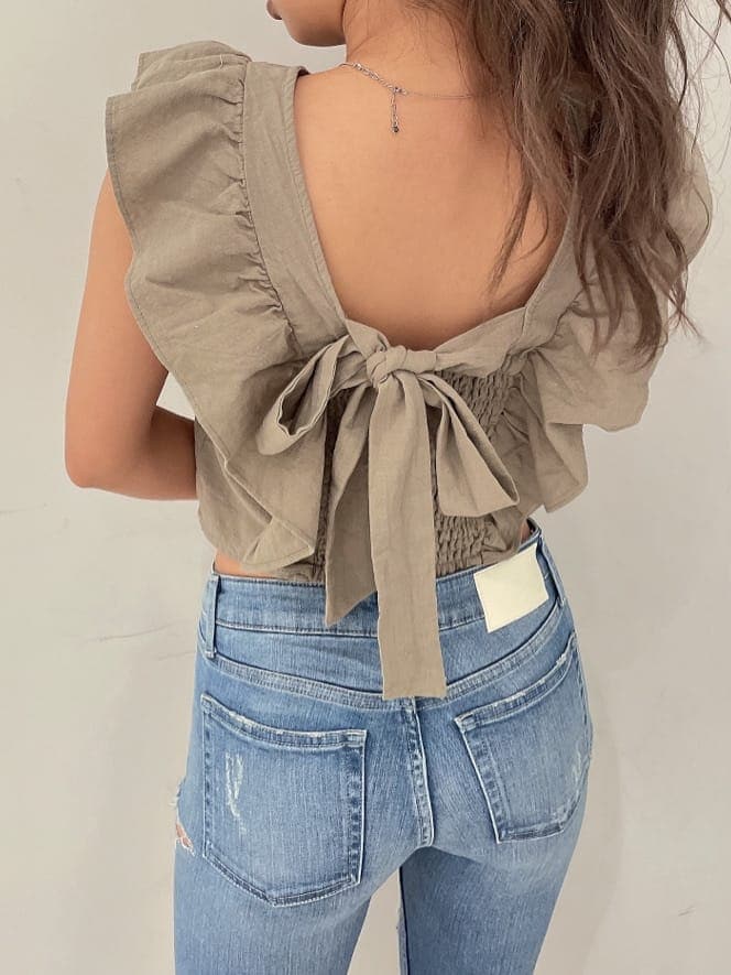 ホワイト系のパンプス、ブルー系のデニムパンツ、ゴールド系のピアス（両耳用）を着用したレディースの夏コーディネートの4枚目の写真