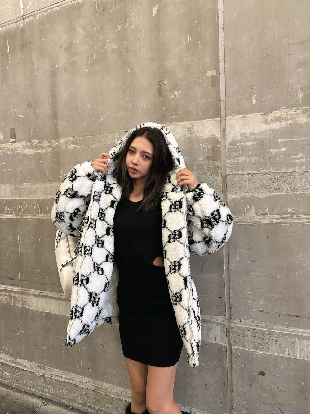 ホワイト系のブルゾン、ブラック系のワンピース、ブラック系のブーツを着用したレディースの秋コーディネートの4枚目の写真