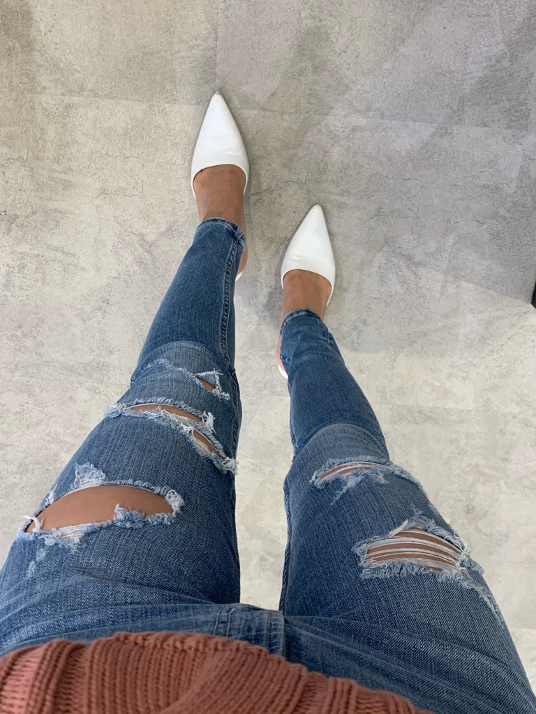 ホワイト系のパンプス、ブルー系のデニムパンツ、レッド系のキャミソールを着用したレディースの春コーディネートの2枚目の写真