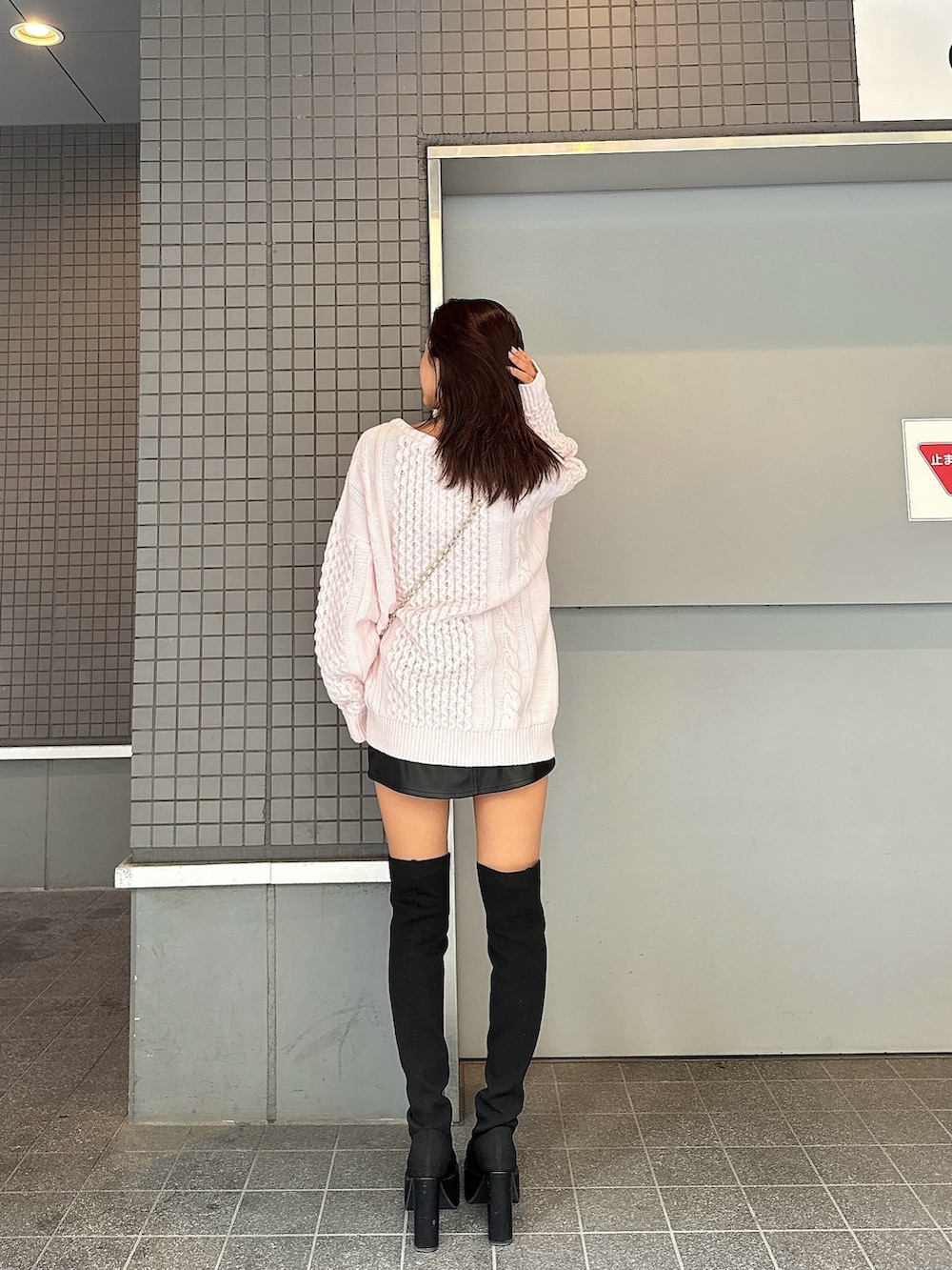 ピンク系のニット/セーター、ブラック系のブーツ、ブラック系のスカートを着用したレディースの秋コーディネートの4枚目の写真