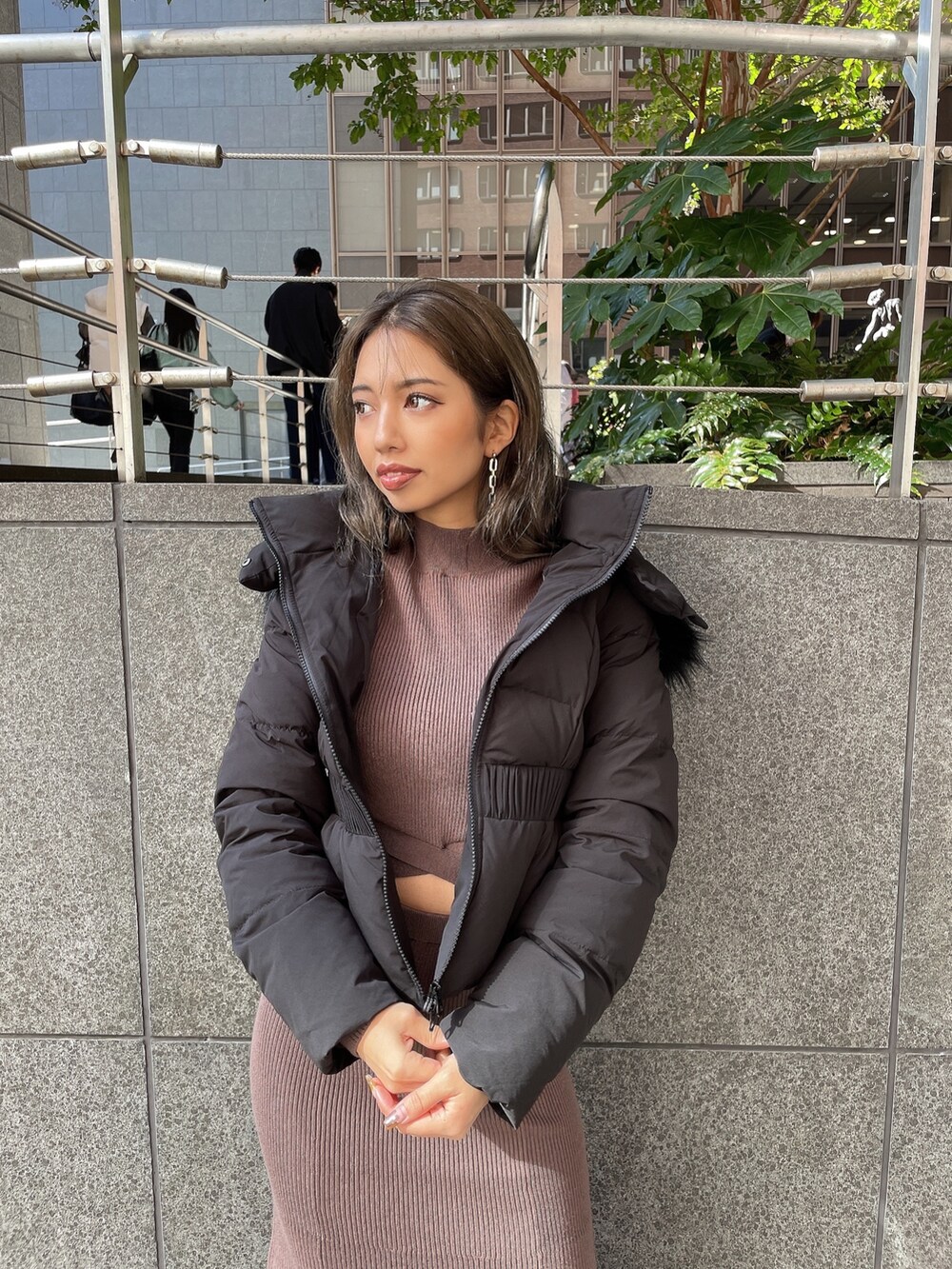 ブラック系のクラッチバッグ、ブラック系のブーツ、ブラウン系のワンピースを着用したレディースの秋コーディネートの8枚目の写真