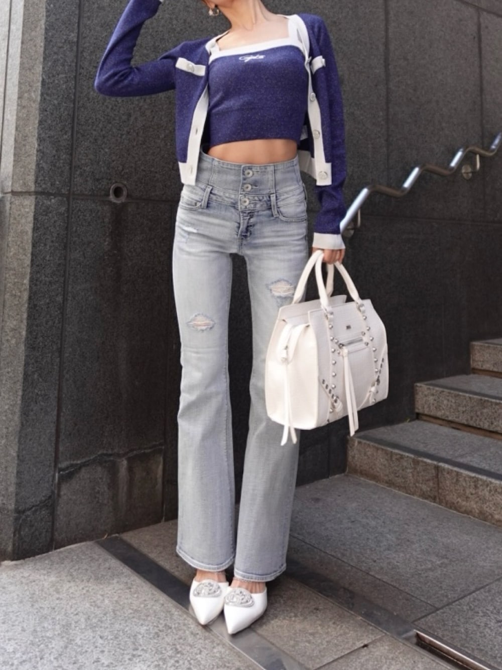 ブルー系のニット/セーター、ブルー系のデニムパンツ、ホワイト系のパンプスを着用したレディースの春コーディネートの3枚目の写真