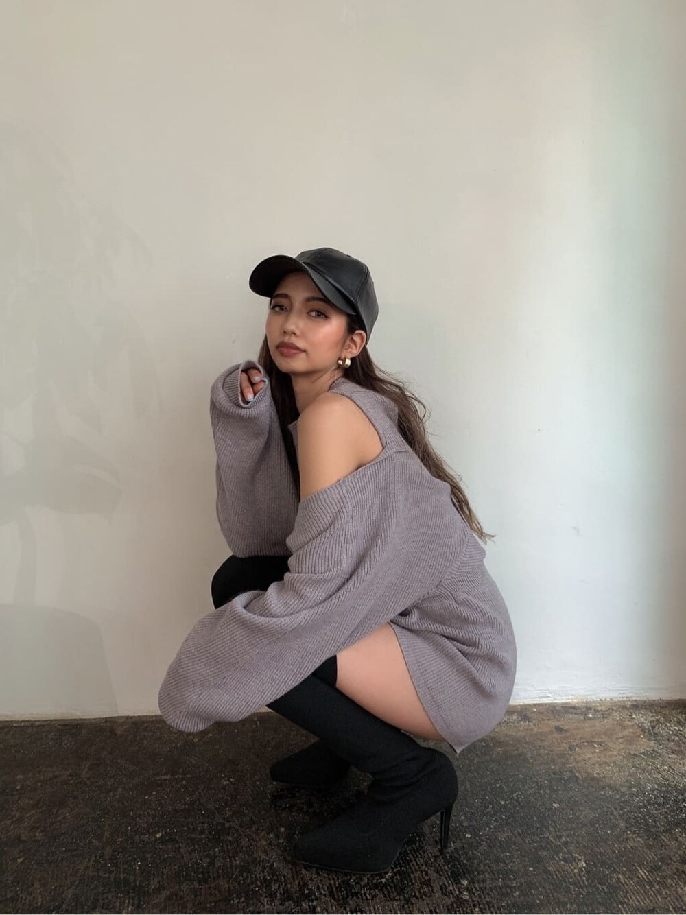 グレー系のつなぎ/オールインワン、ブラック系のブーツ、ブラック系のキャップを着用したレディースの秋コーディネートの5枚目の写真