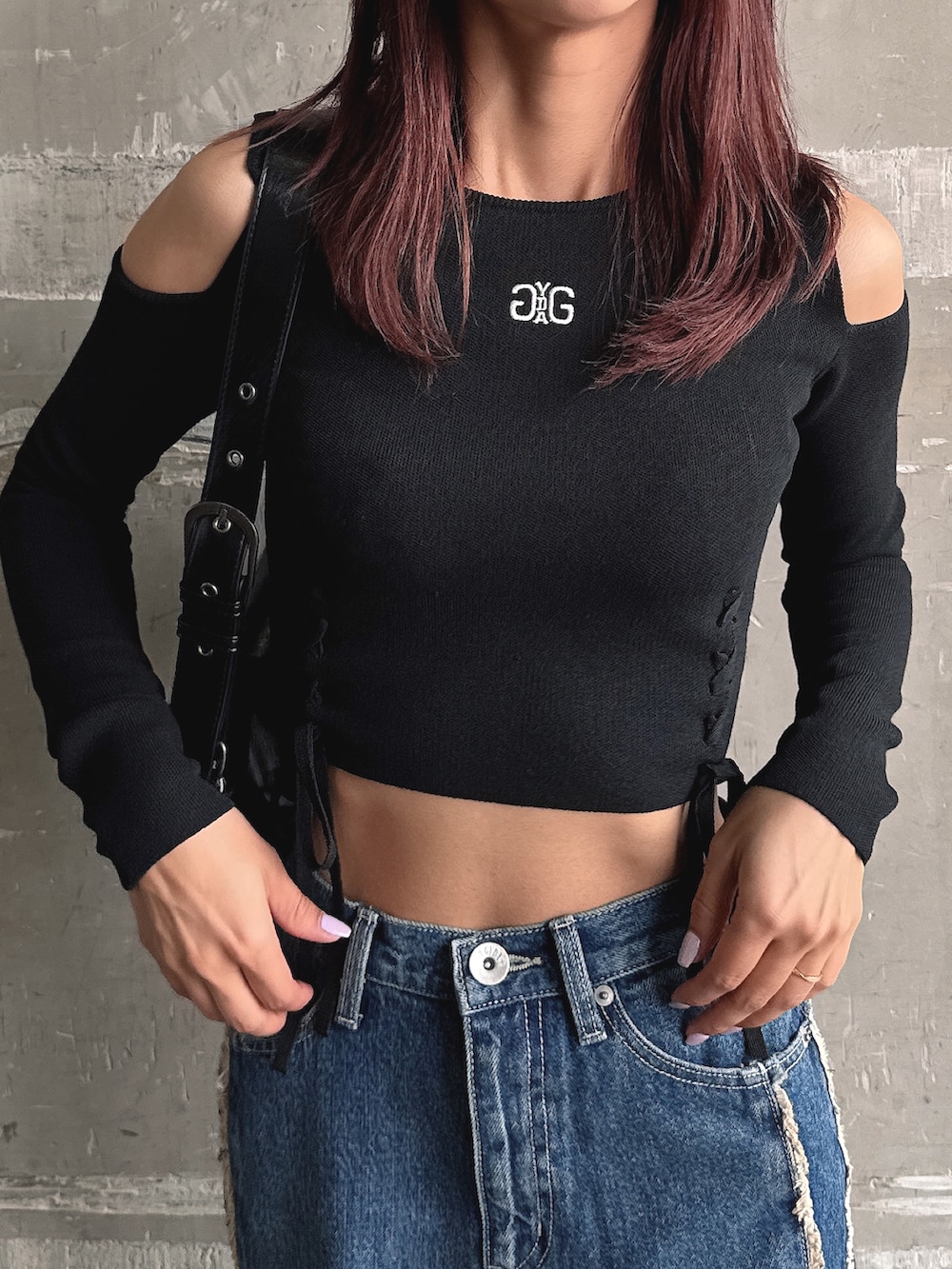 ブルー系のデニムパンツ、ブラック系のニット/セーター、ブラック系のハンドバッグを着用したレディースの秋コーディネートの8枚目の写真