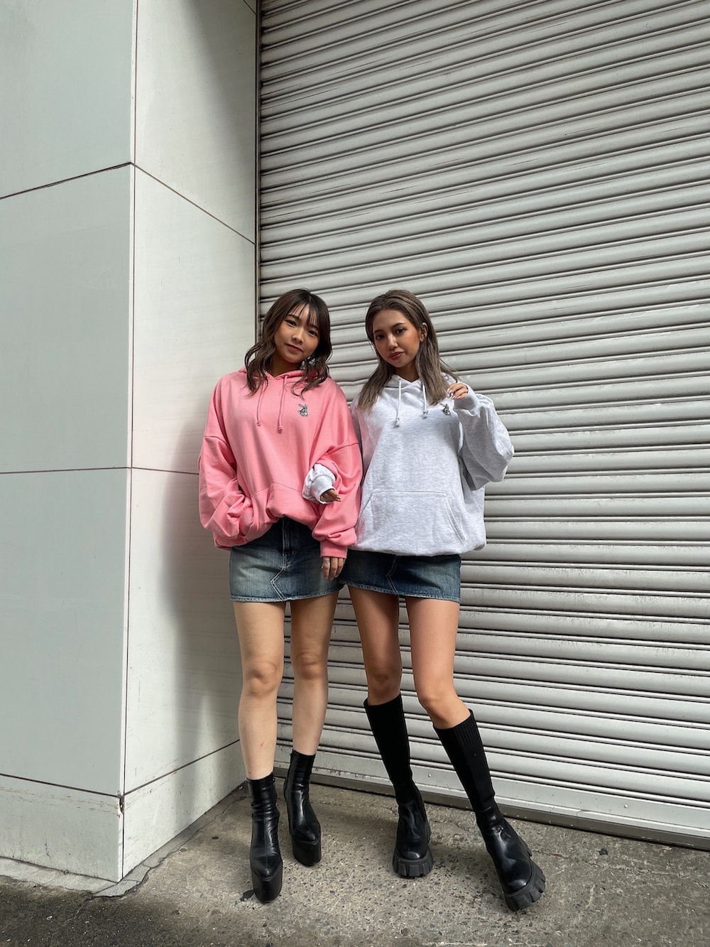 グレー系のパーカー、ピンク系のパーカー、ブルー系のデニムスカートを着用したレディースの冬コーディネートの3枚目の写真