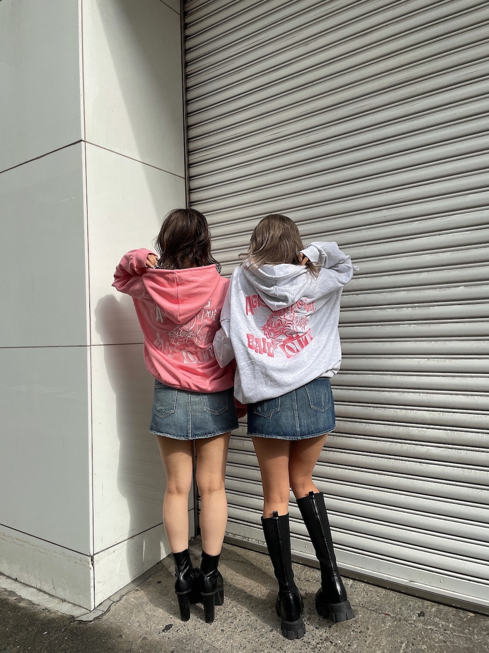 グレー系のパーカー、ピンク系のパーカー、ブルー系のデニムスカートを着用したレディースの冬コーディネートの2枚目の写真