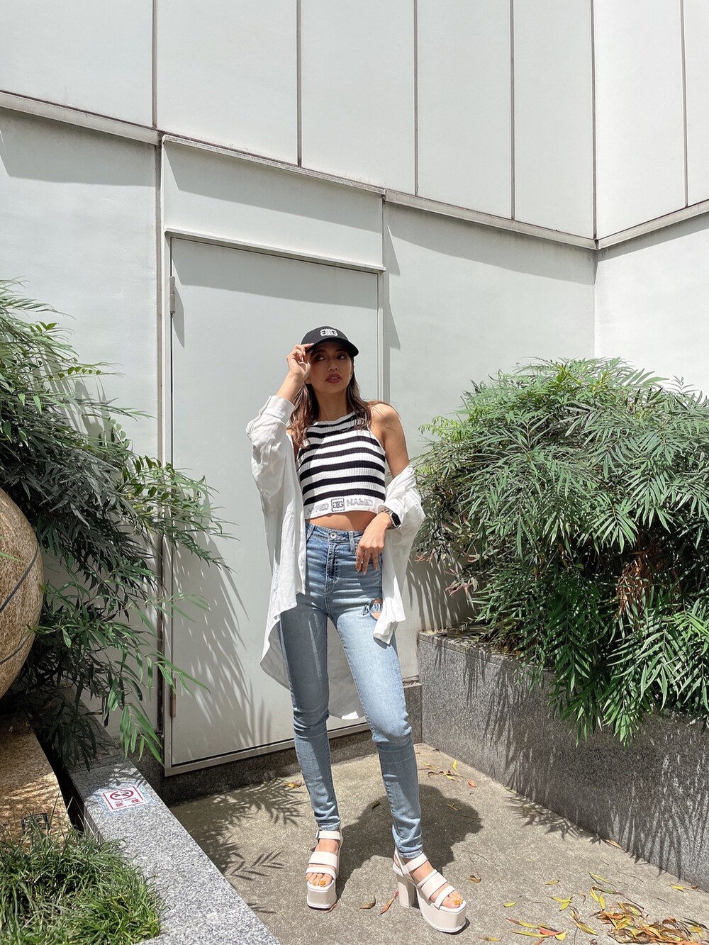 その他のタンクトップ、ブルー系のデニムパンツ、ホワイト系のサンダルを着用したレディースの春コーディネートの4枚目の写真