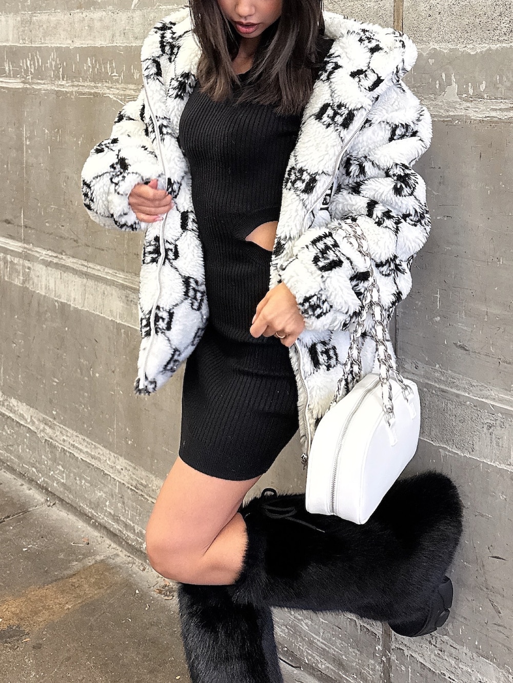 ホワイト系のブルゾン、ブラック系のワンピース、ブラック系のブーツを着用したレディースの秋コーディネートの8枚目の写真